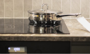 A stainless steel pot rests on an induction cooker, representing proper cookware use to extend the appliance's lifespan.