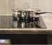 A stainless steel pot rests on an induction cooker, representing proper cookware use to extend the appliance's lifespan.